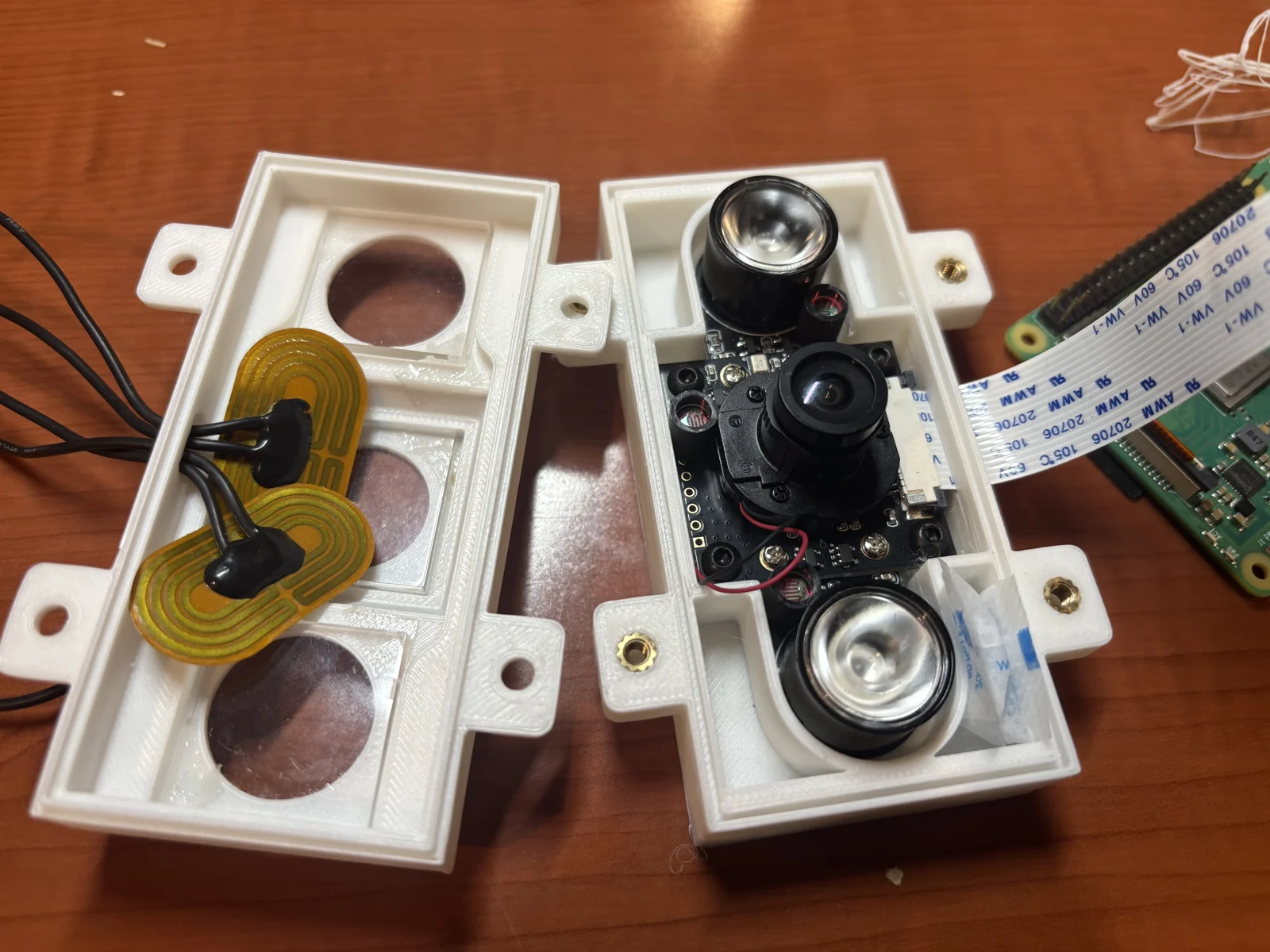 Opened fridge camera enclosure showing electronics and optical windows